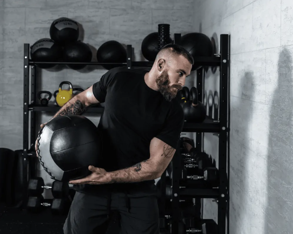 A hockey player using a medicine ball for a rotational strengthening exercise.