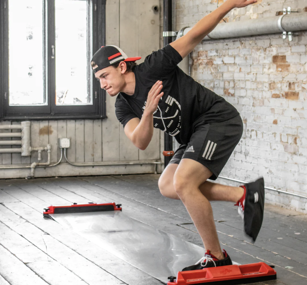 A hockey player using a slide board to practice his skating stride and lateral movement.